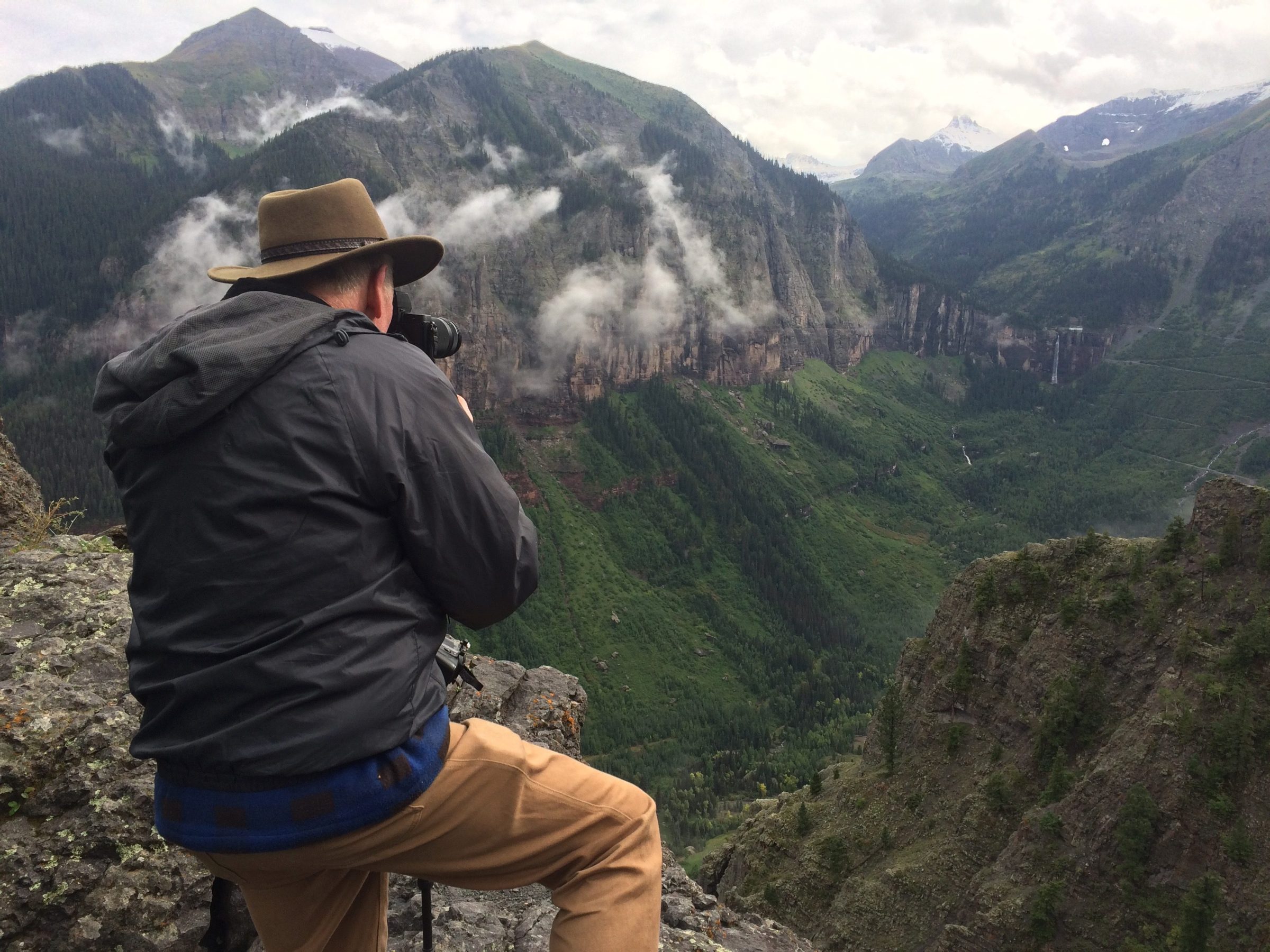 a man sitting on the side of a mountain