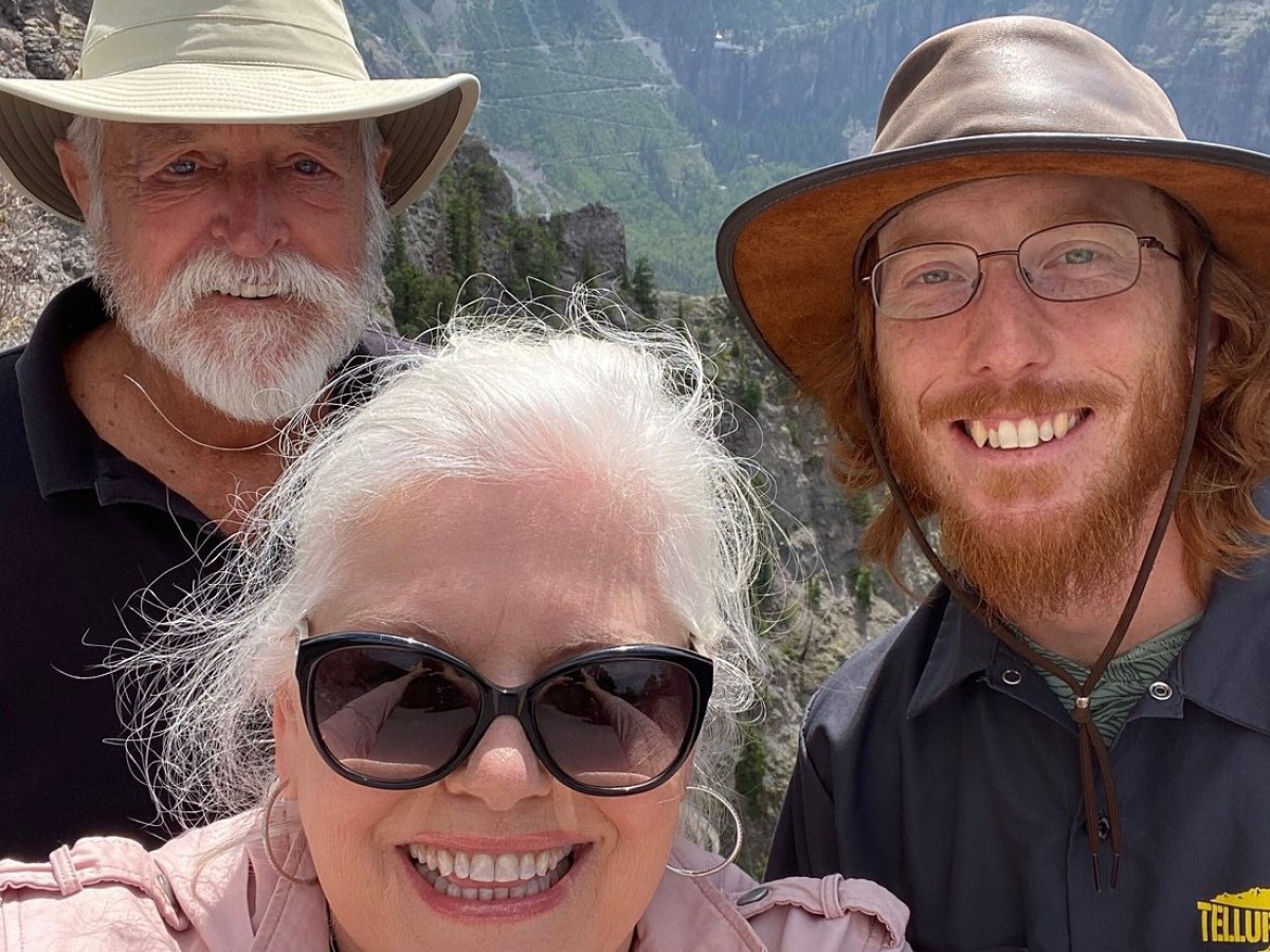 a couple of people standing on top of a mountain